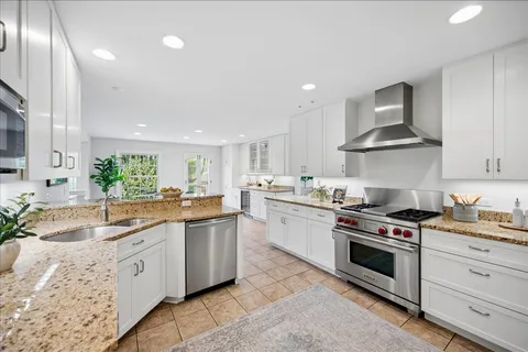a kitchen with granite countertop stainless steel appliances a sink and cabinets