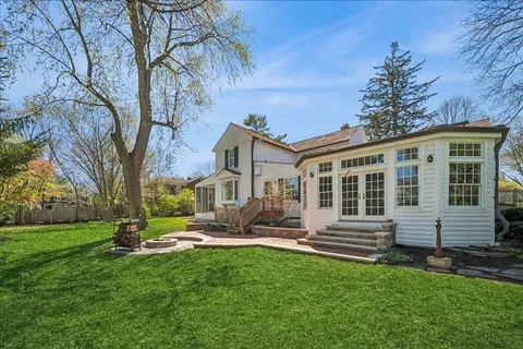 a front view of a house with garden and trees