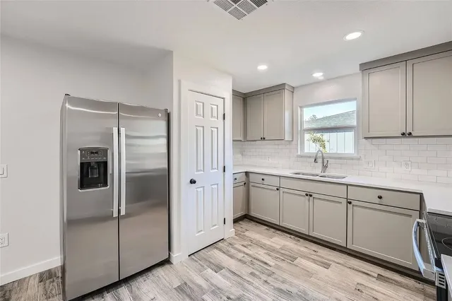 a kitchen with stainless steel appliances granite countertop a refrigerator and a sink