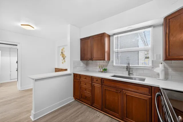 a view of a kitchen with wooden floor and a refrigerator