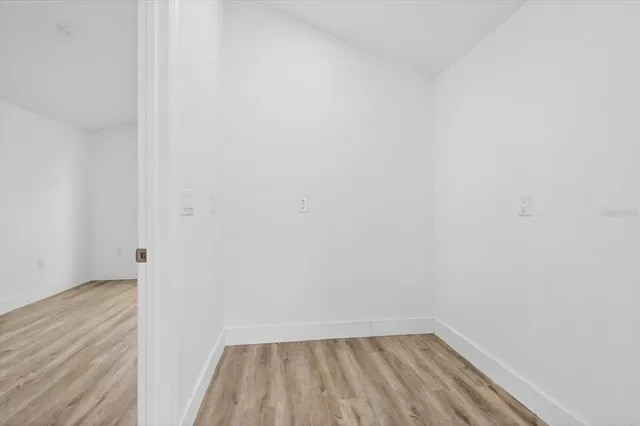 a view of empty room with wooden floor