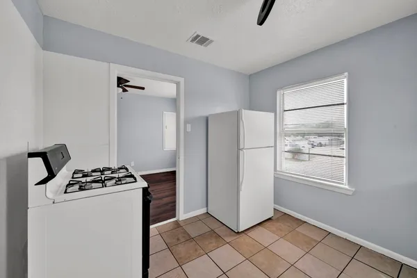 a kitchen that has a refrigerator and a stove in it