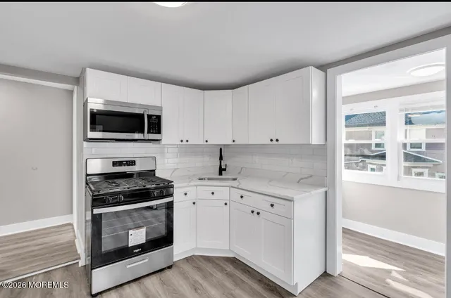 a kitchen with granite countertop a sink and a stove top oven