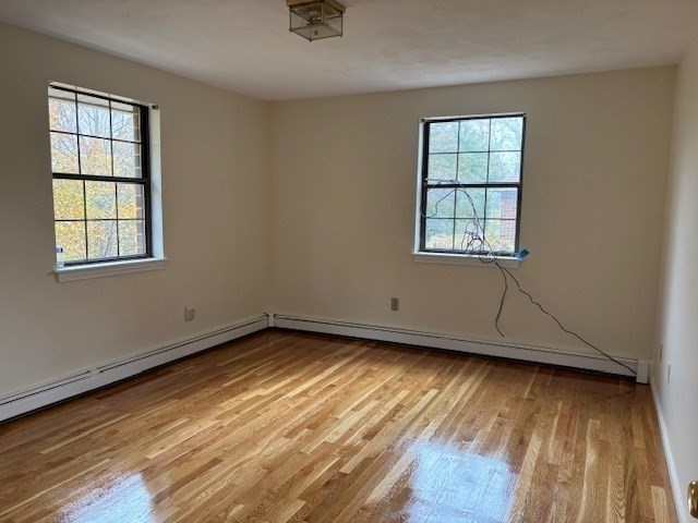 317 Cross Street, Unit 317 Winchester, MA 01890 - Photo 13 of 16 an empty room with wooden floor and windows