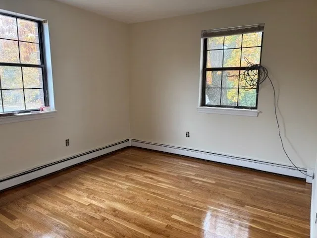 a view of a room with wooden floor and a window