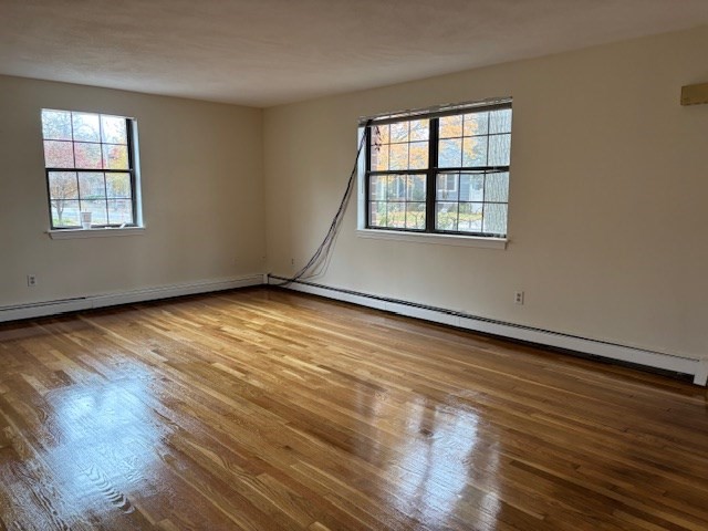 317 Cross Street, Unit 317 Winchester, MA 01890 - Photo 4 of 16 an empty room with wooden floor and windows