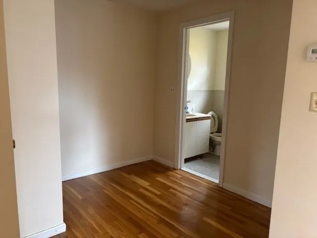 a bathroom with a granite countertop toilet a sink and a window