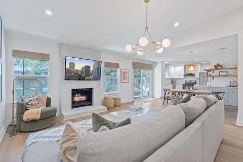 a living room with furniture a fireplace and a chandelier