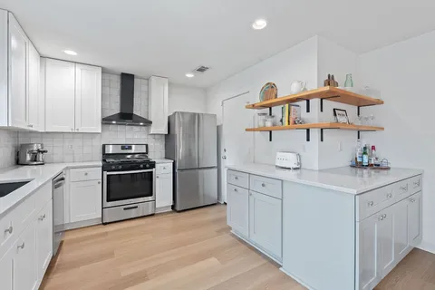 a kitchen with stainless steel appliances a refrigerator sink and cabinets