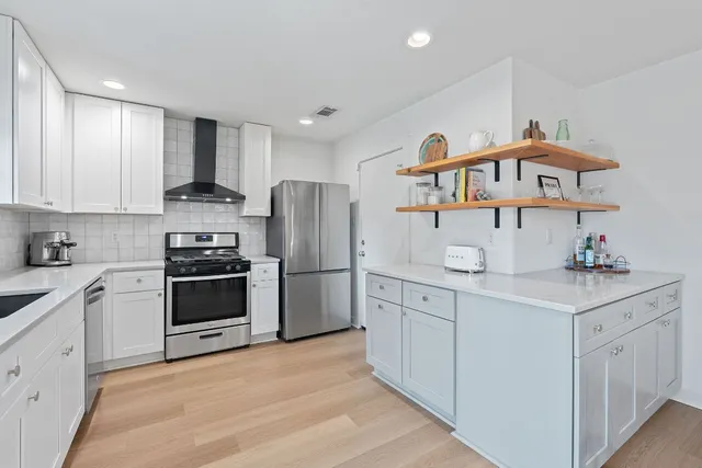 a kitchen with stainless steel appliances a refrigerator sink and cabinets