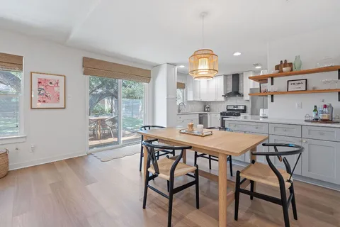 a view of a patio with table and chairs with wooden floor and fence