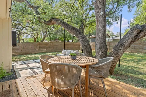 a backyard of a house with table and chairs