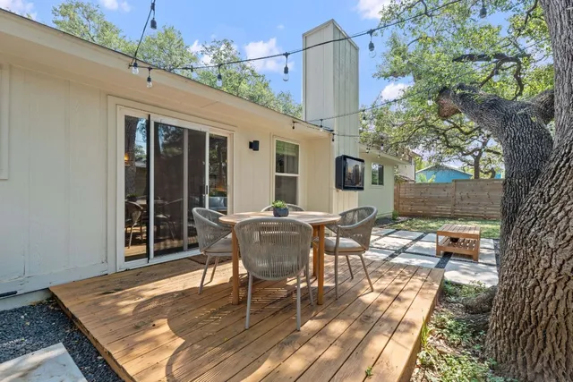 a view of a house with backyard and tree