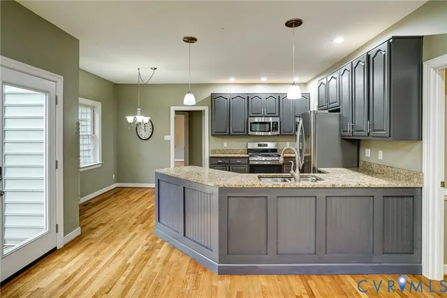 a kitchen with kitchen island granite countertop a sink cabinets and stainless steel appliances
