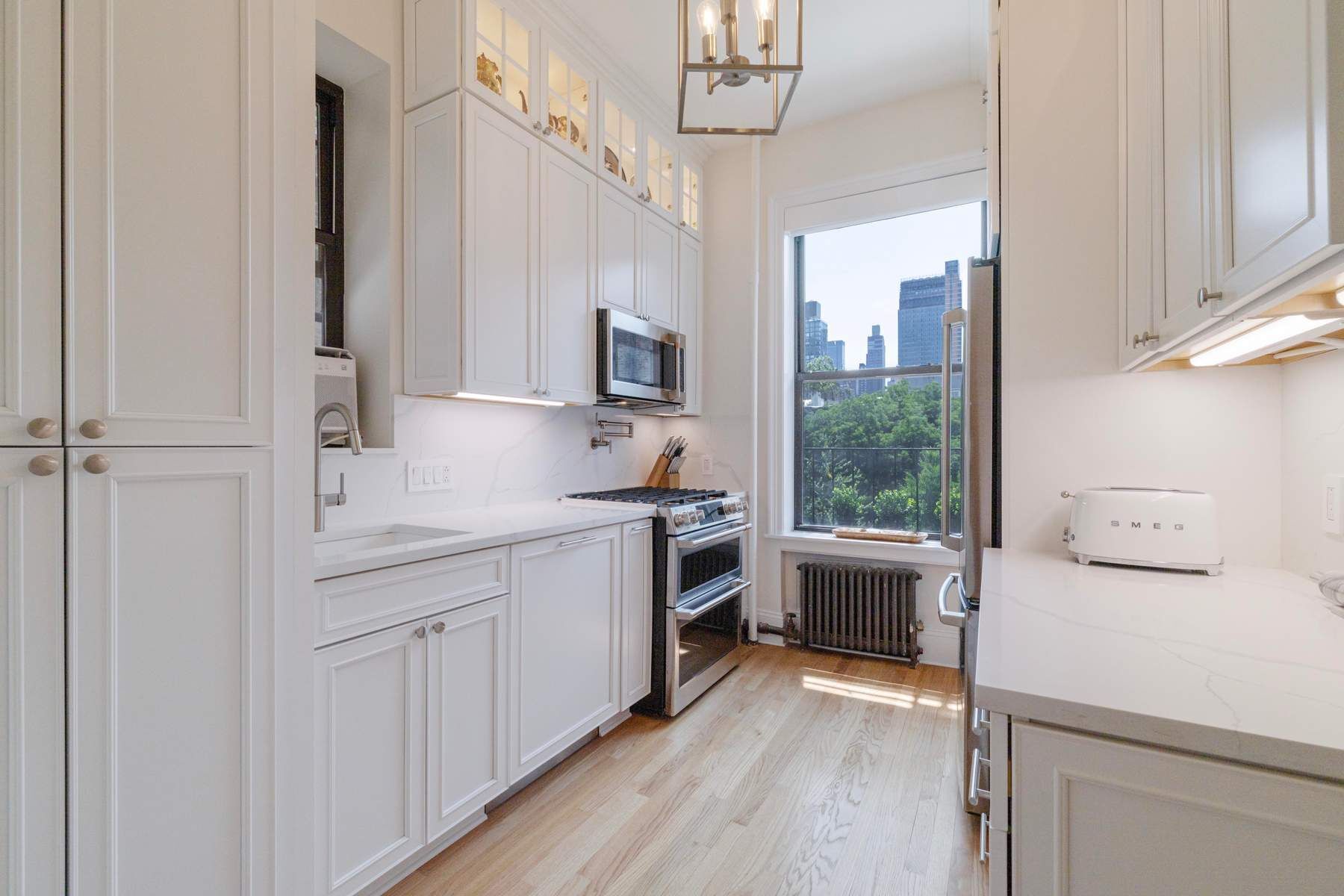350 West 48th Street, Unit 4E Manhattan, NY 10036 - Photo 4 of 12 a kitchen with a stove a sink and a refrigerator