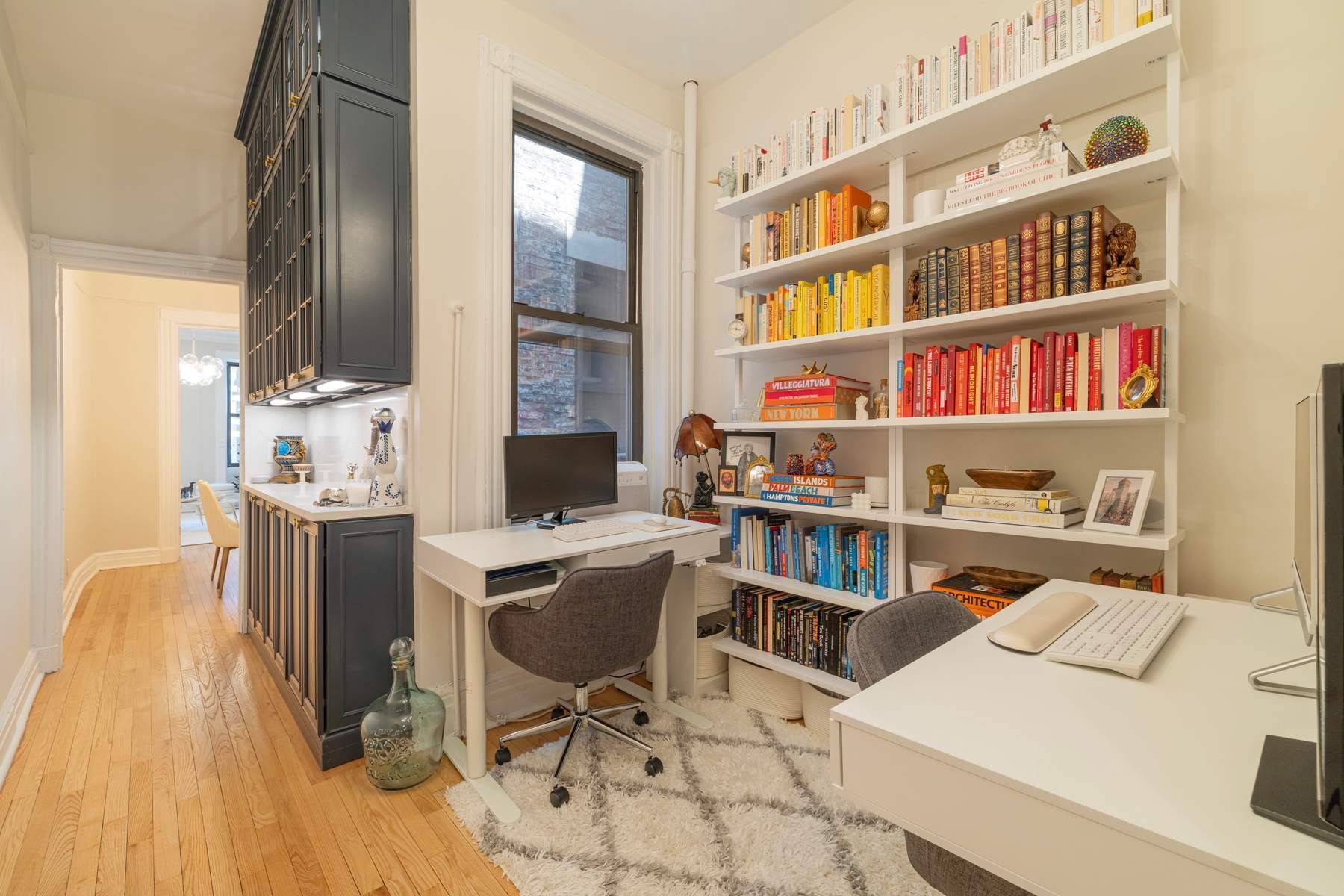 350 West 48th Street, Unit 4E Manhattan, NY 10036 - Photo 6 of 12 a view of a workspace with furniture and a book shelf