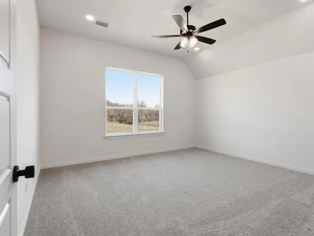 an empty room with a window and a ceiling fan