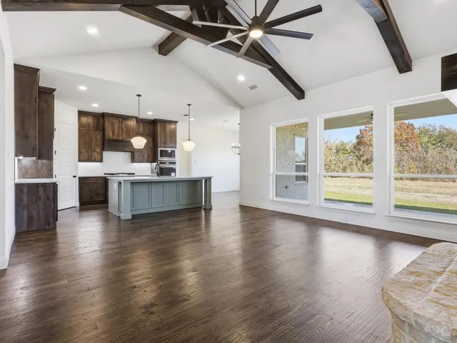 a living room with stainless steel appliances kitchen island granite countertop a stove and a large window