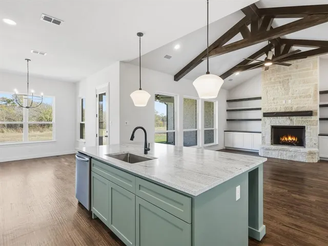 a kitchen with kitchen island a sink a counter space appliances and cabinets