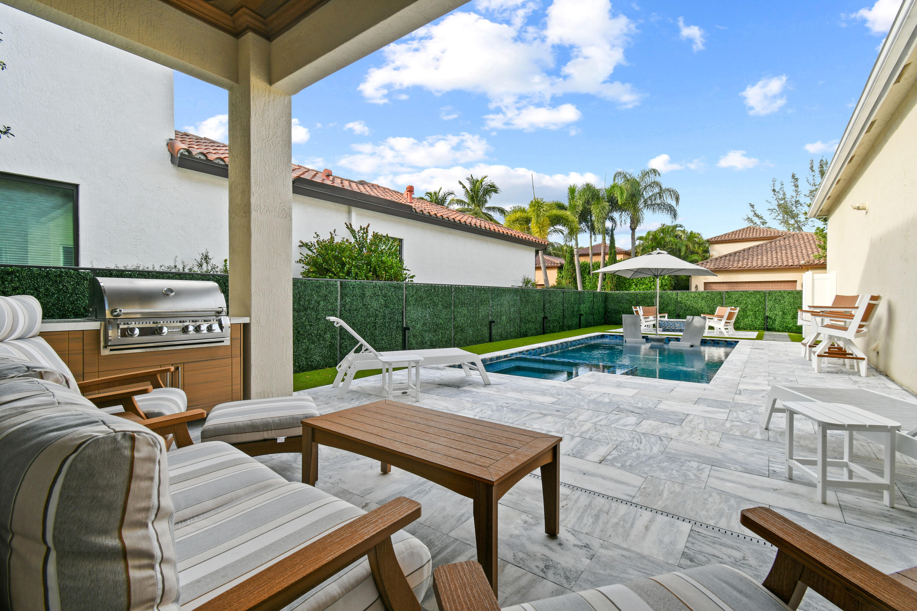 123 Barcelona Drive Jupiter, FL 33458 - Photo 38 of 59 a view of a patio with couches table and chairs with wooden fence