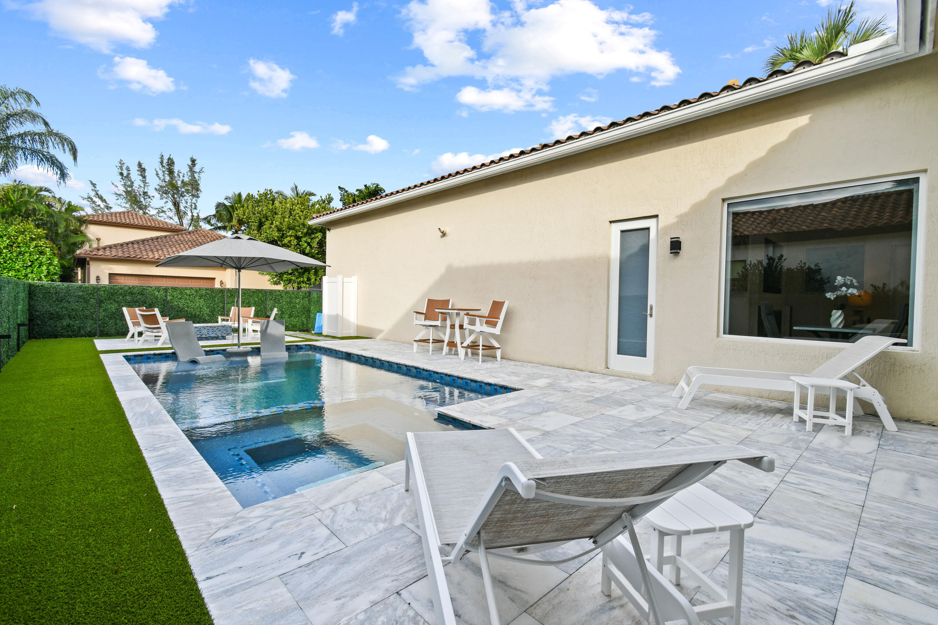 123 Barcelona Drive Jupiter, FL 33458 - Photo 39 of 59 a view of a patio with dining table and chairs with wooden floor
