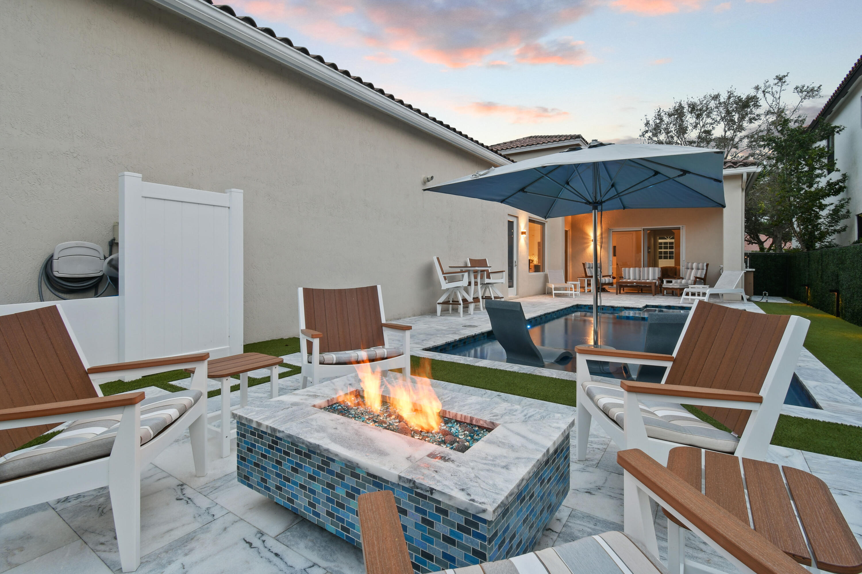 123 Barcelona Drive Jupiter, FL 33458 - Photo 51 of 59 a view of a patio with table and chairs under an umbrella with a barbeque