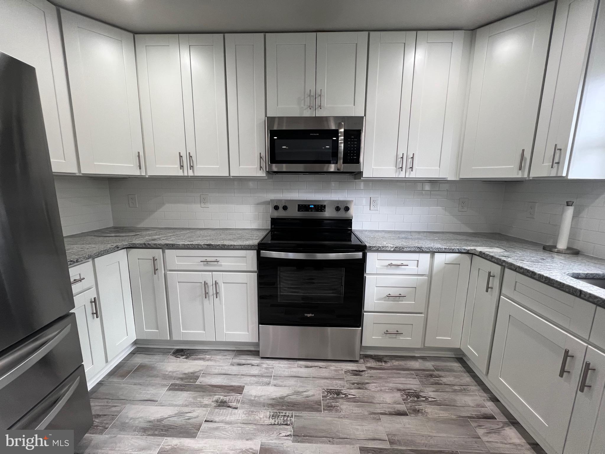 1206 Sycamore Avenue Croydon, PA 19021 - Photo 6 of 24 a kitchen with granite countertop white cabinets and stainless steel appliances