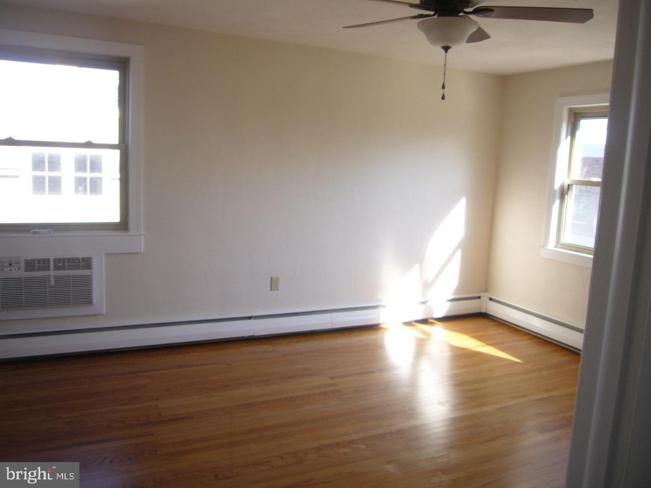 231 Sharpless Street, Unit 3A West Chester, PA 19382 - Photo 5 of 9 a view of an empty room with a window and wooden floor