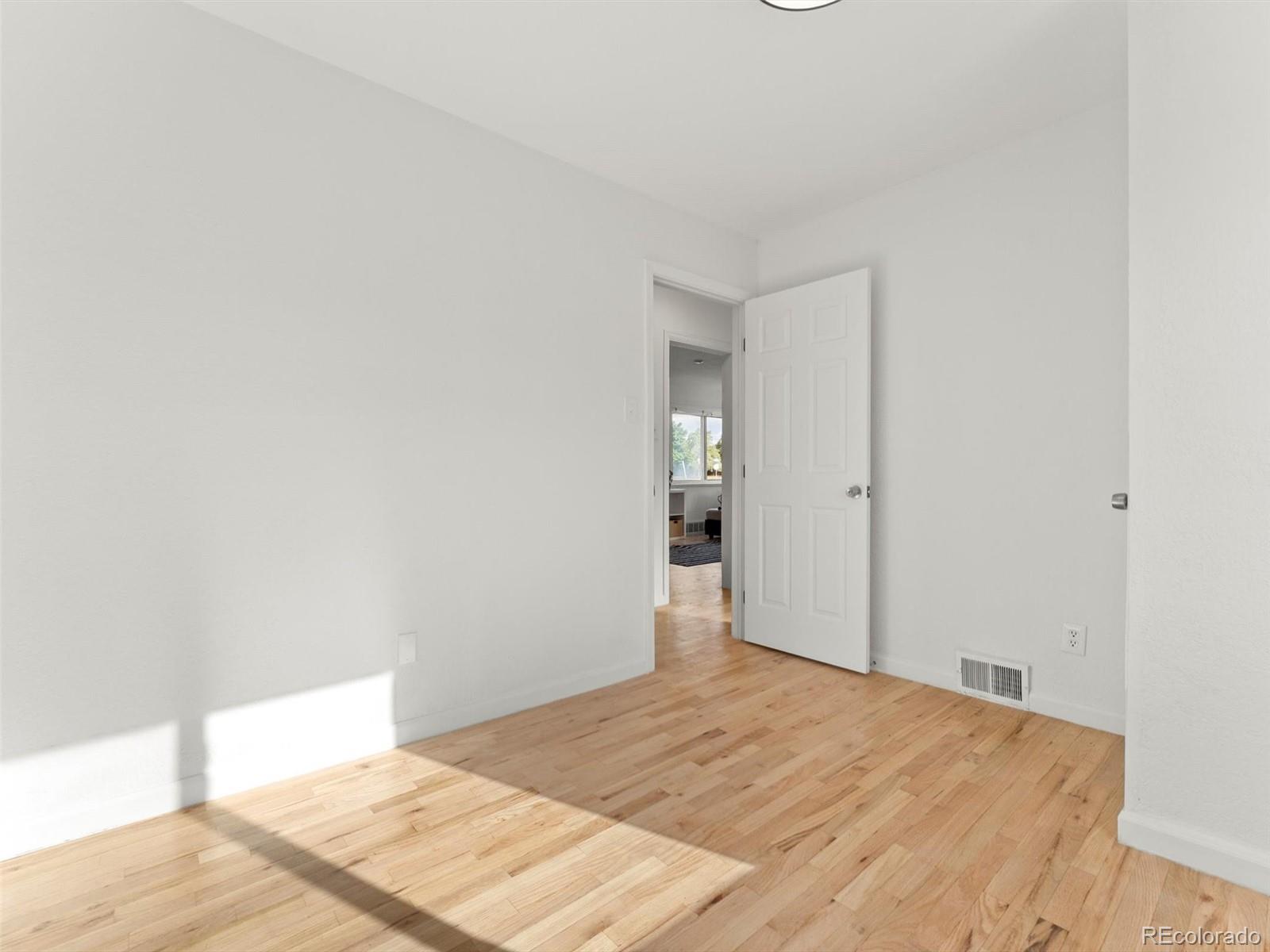 2865 Quebec Street Denver, CO 80207 - Photo 14 of 30 a bedroom with a bed and a table