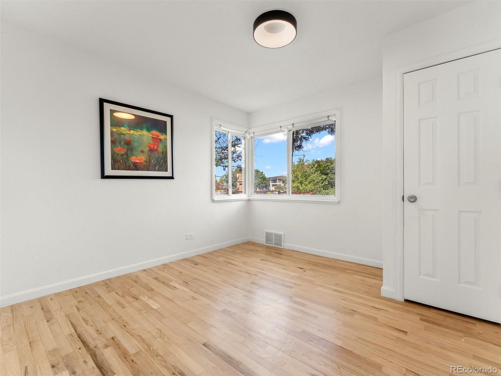 2865 Quebec Street Denver, CO 80207 - Photo 19 of 30 an empty room with wooden floor and window