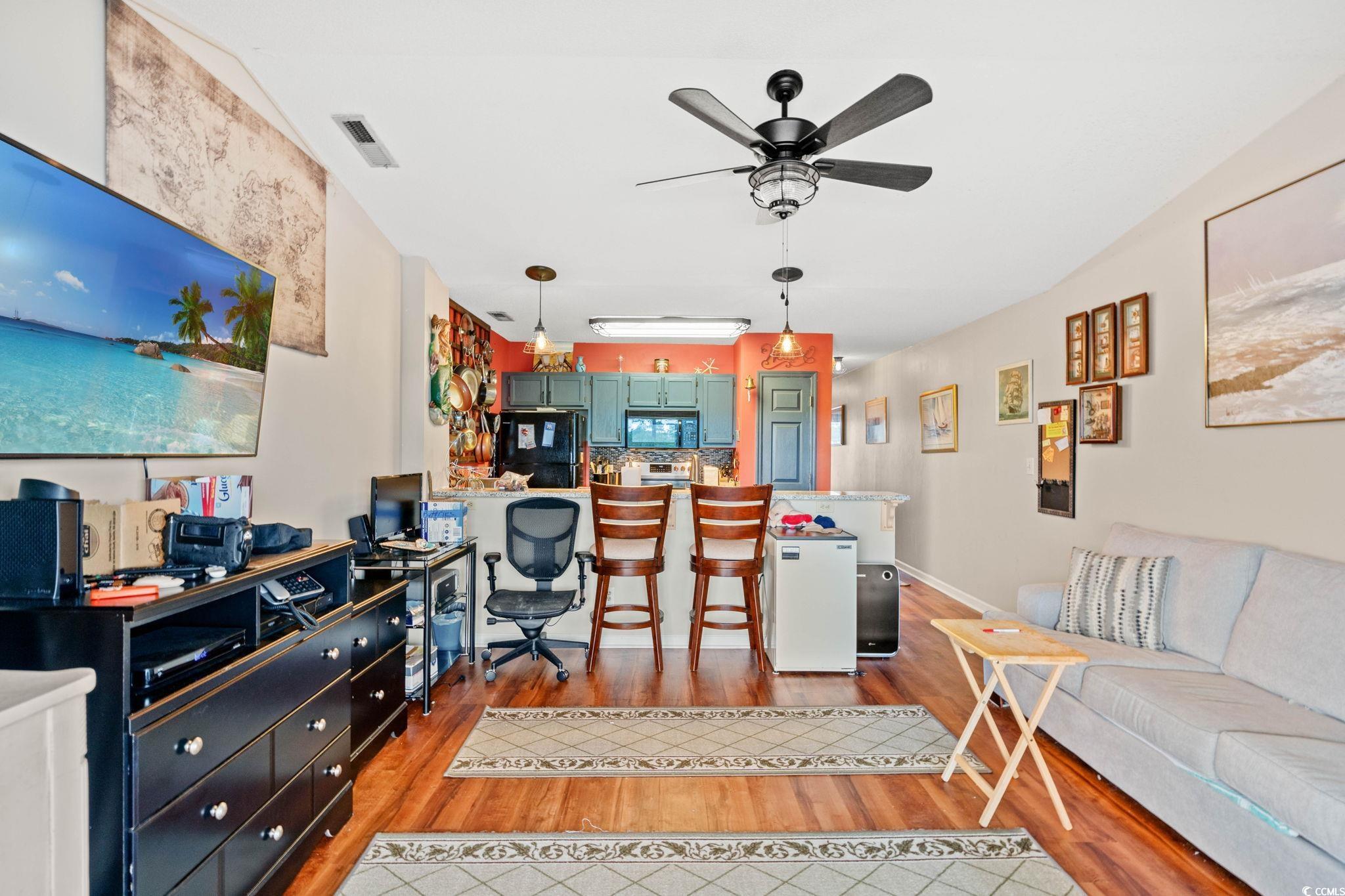 216 Landing Road, Unit H216 North Myrtle Beach, SC 29582 - Photo 11 of 23 Kitchen featuring hanging light fixtures, stainless steel electric range oven, black microwave, an island with sink, and vaulted ceiling