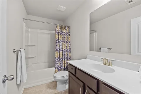 a living room with a flat screen tv on dresser and a table