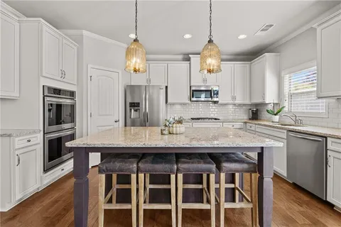 a kitchen with granite countertop a sink center island and refrigerator