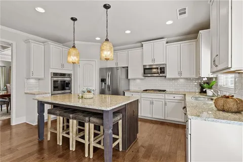 a kitchen with stainless steel appliances granite countertop a stove a sink a microwave and cabinets