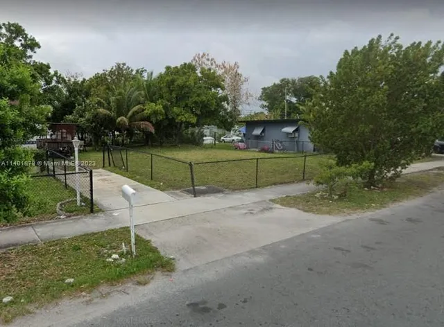 a green field with trees in the background
