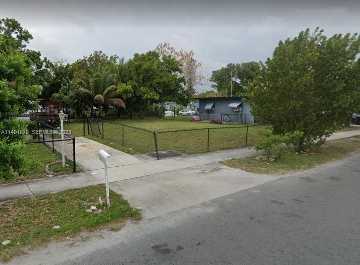 4 Nw Court Pompano Beach, FL 33069 - Photo 8 of 9 a green field with trees in the background