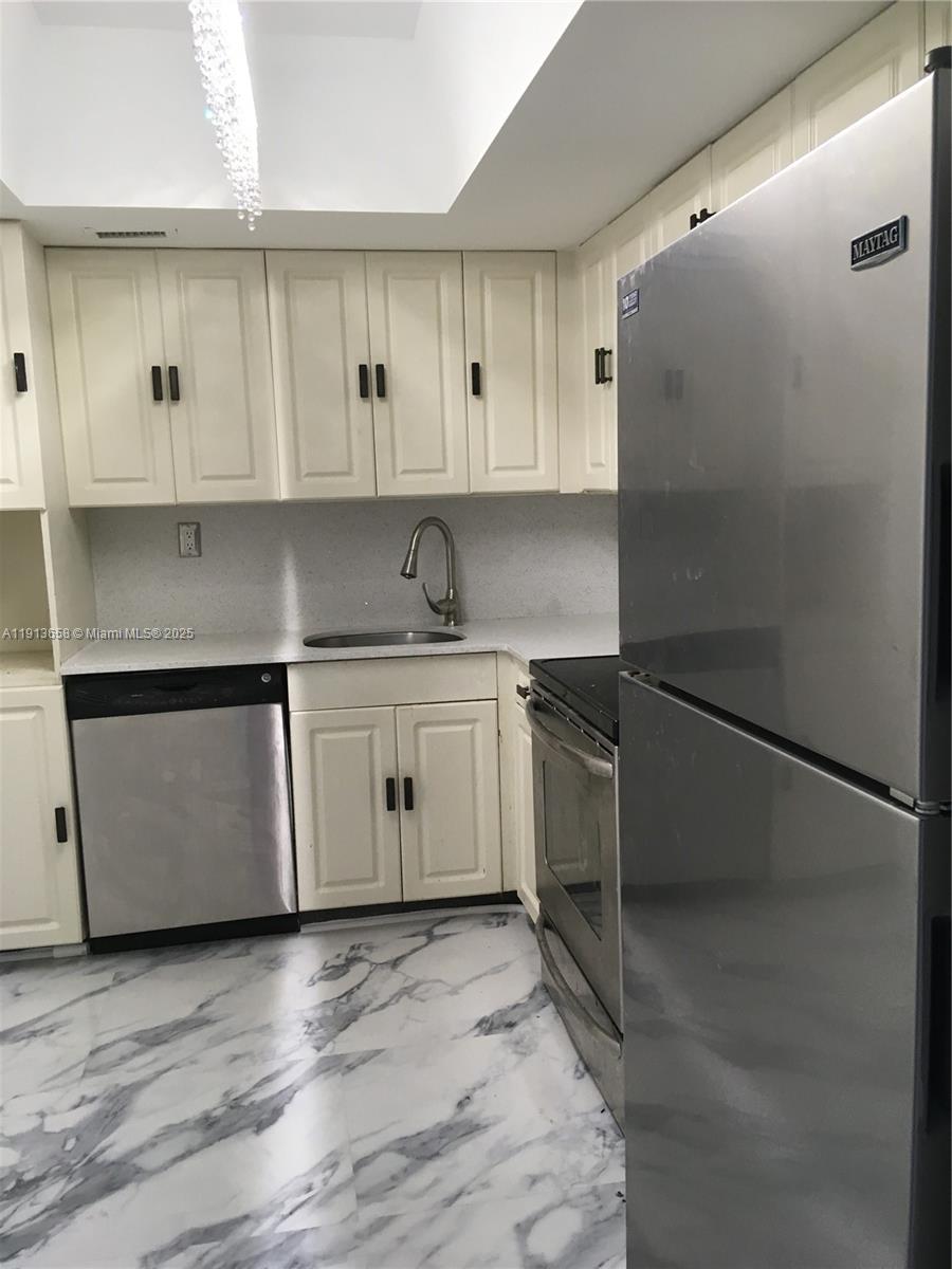 5838 Collins Avenue, Unit PHF Miami Beach, FL 33140 - Photo 5 of 16 a kitchen with a sink stove and refrigerator