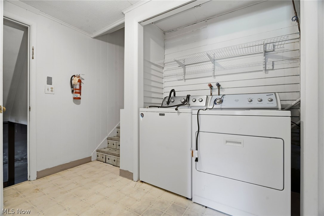 759 Runkle Avenue Ashtabula, OH 44004 - Photo 21 of 40 Dedicated laundry area featuring a washer and dryer, slat wall paneling with wire shelving, and durable flooring