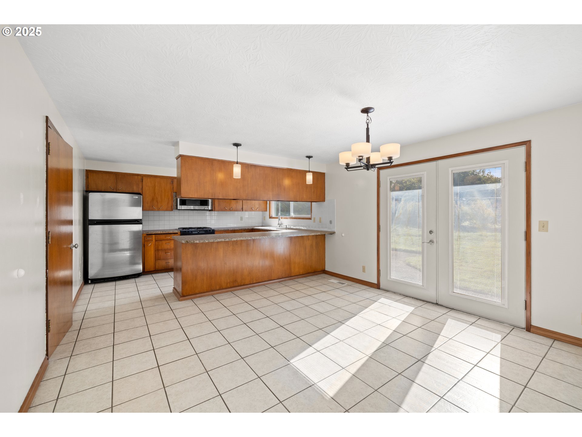 3396 Southeast Loeffelman Road Milwaukie, OR 97222 - Photo 11 of 41 a kitchen with stainless steel appliances kitchen island granite countertop a refrigerator and a stove top oven