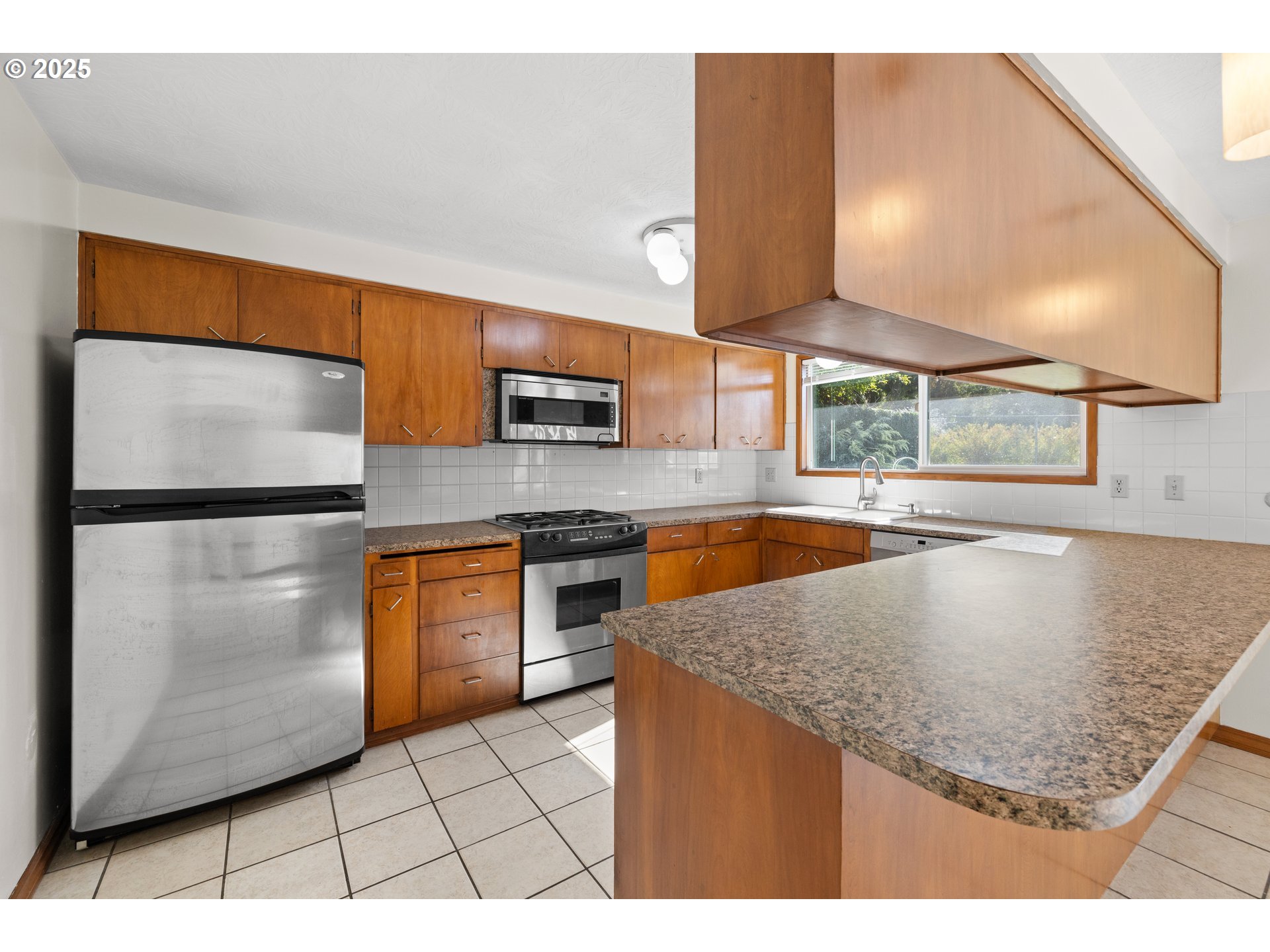 3396 Southeast Loeffelman Road Milwaukie, OR 97222 - Photo 12 of 41 a kitchen with stainless steel appliances granite countertop a sink a microwave a stove and a refrigerator