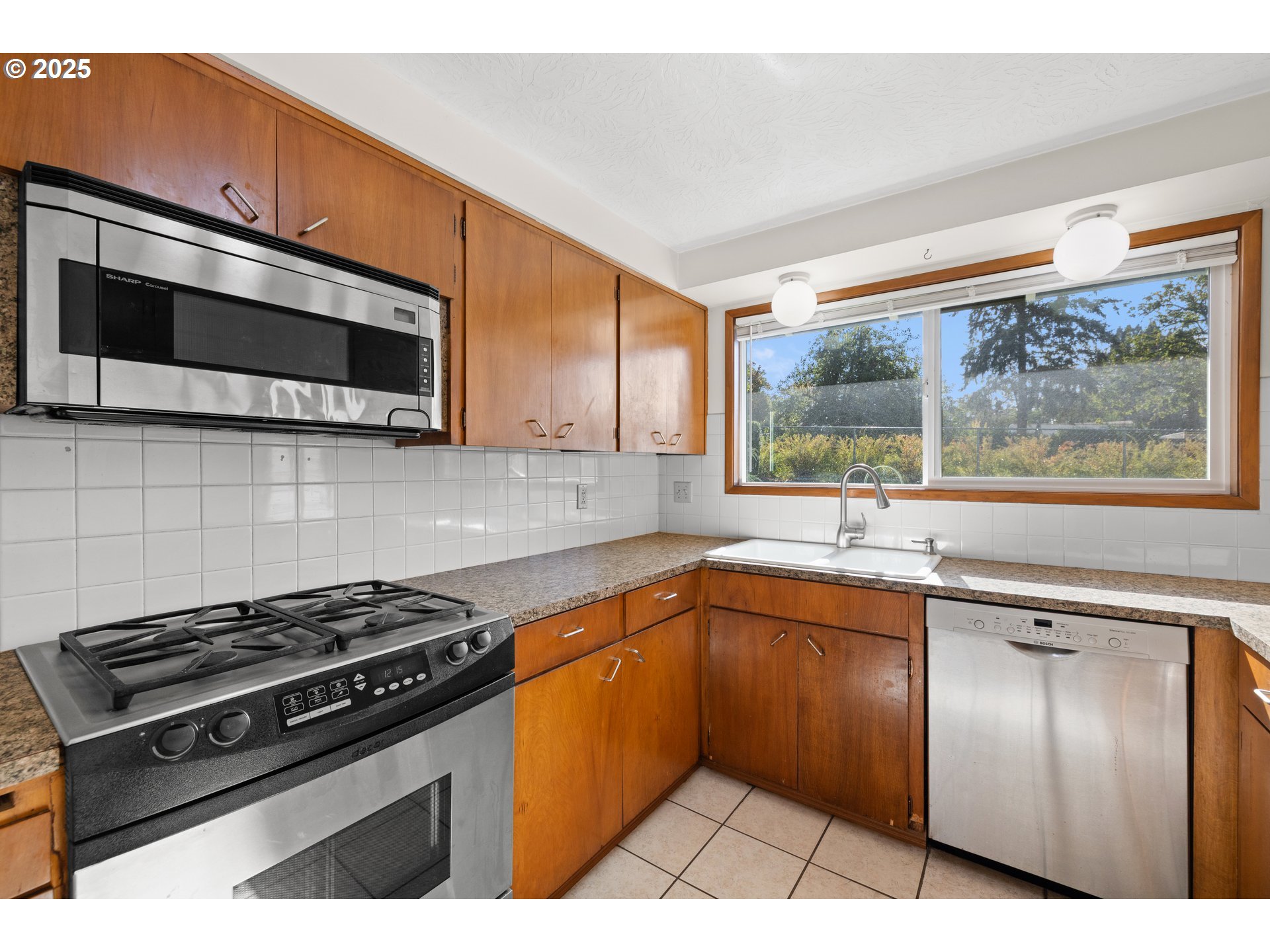 3396 Southeast Loeffelman Road Milwaukie, OR 97222 - Photo 14 of 41 a kitchen with stainless steel appliances a stove sink and microwave