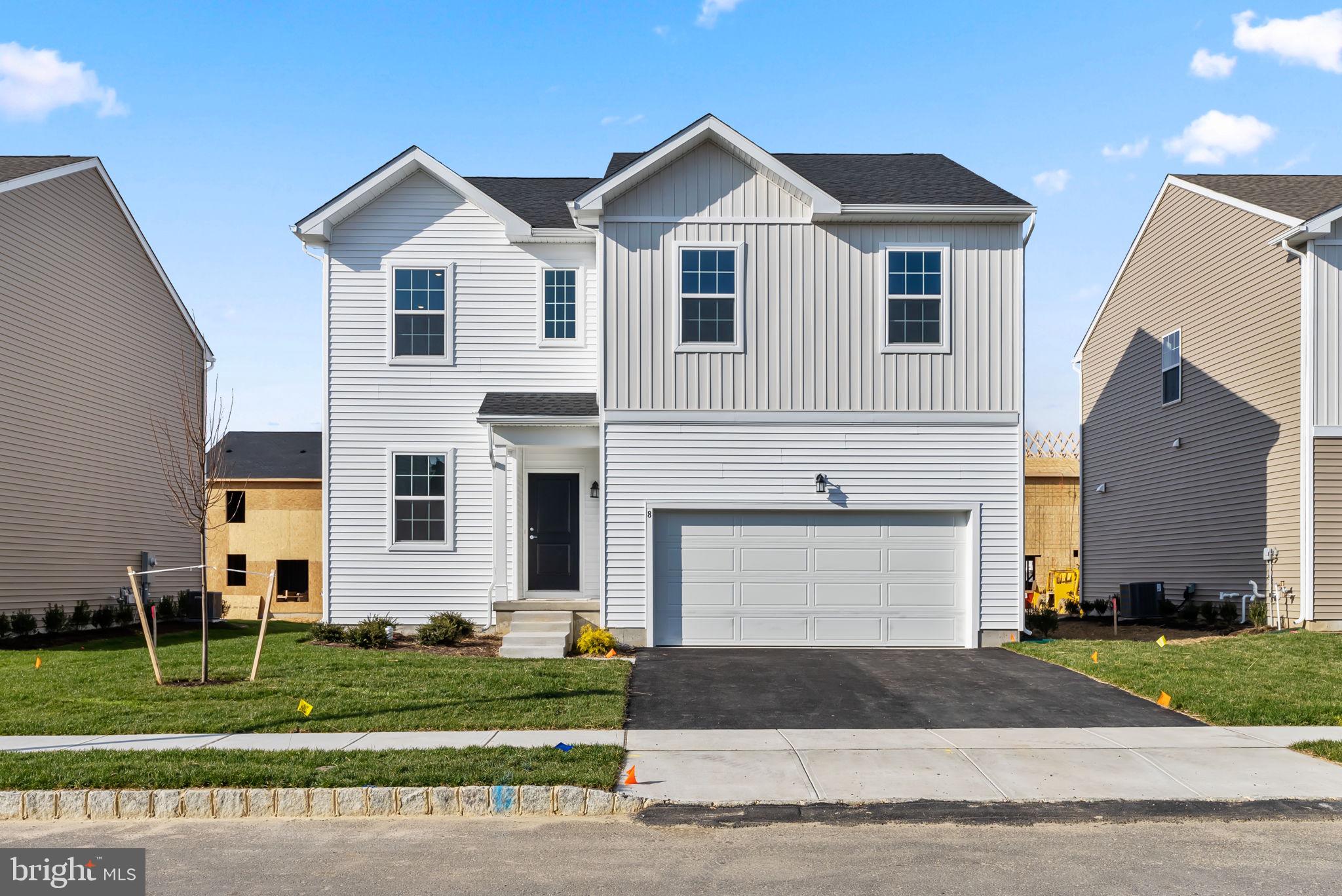 a front view of a house with a yard and a garage