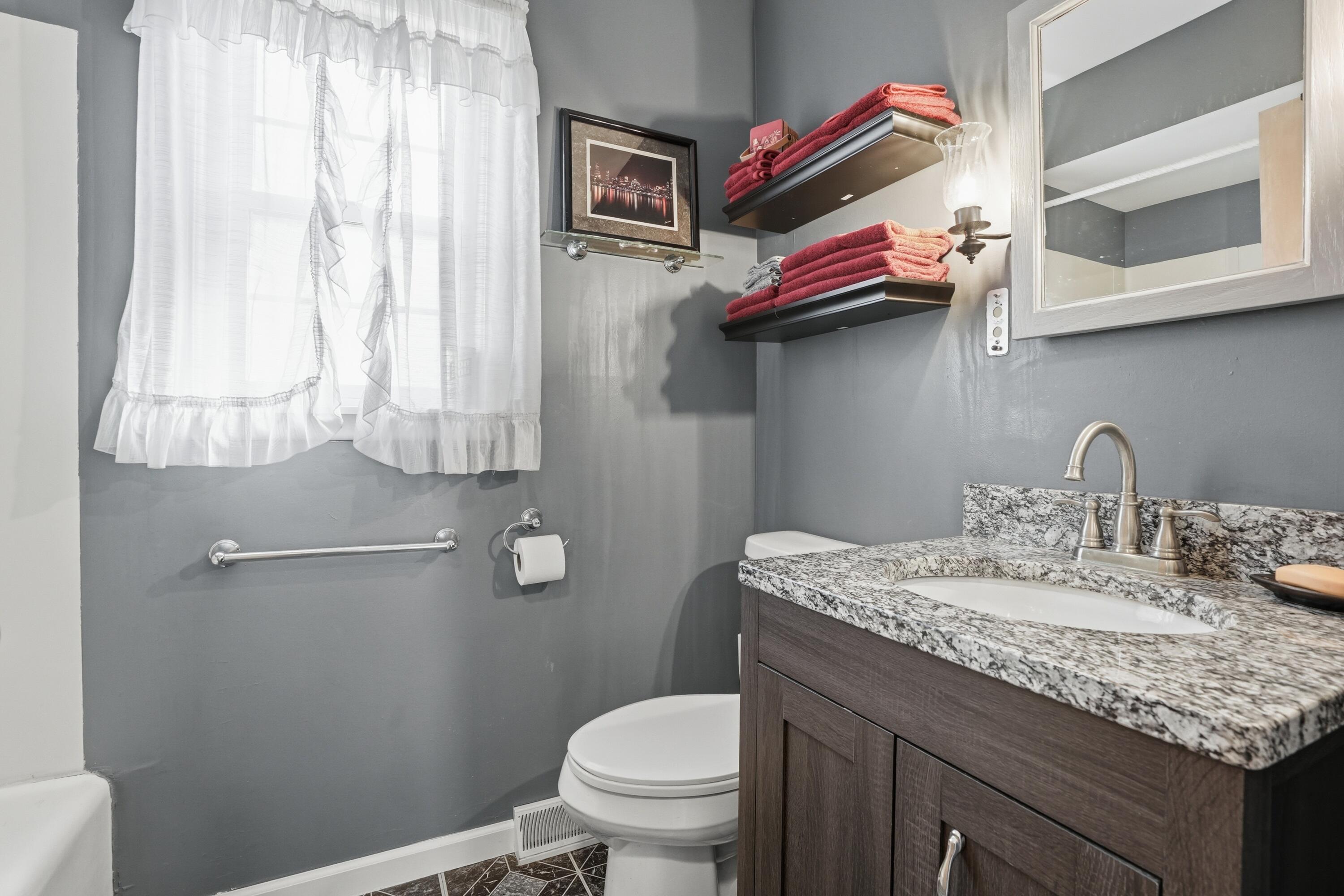 8951 State Line Road Dyer, IN 46311 - Photo 12 of 28 a bathroom with a granite countertop toilet sink and mirror