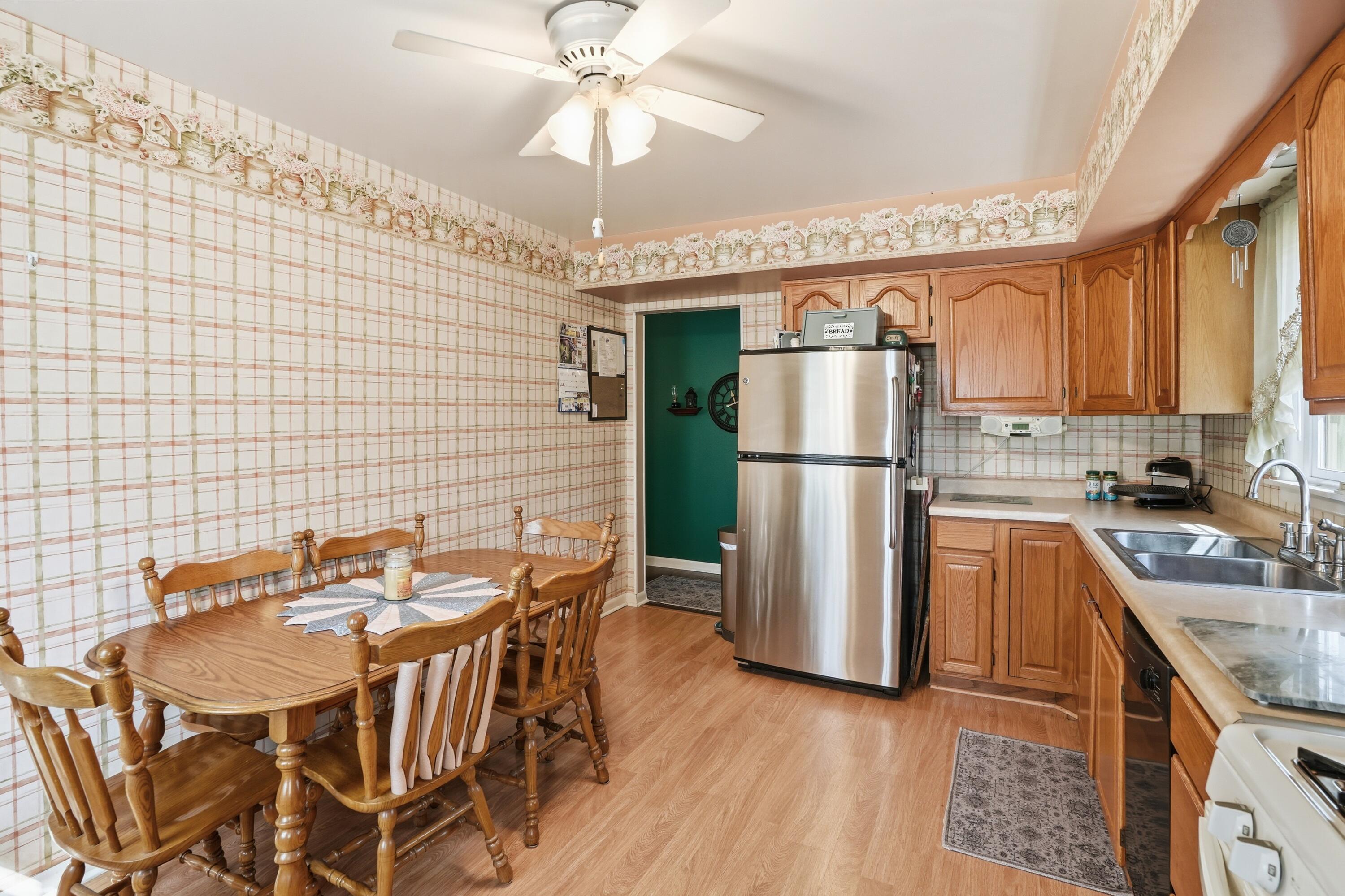 8951 State Line Road Dyer, IN 46311 - Photo 7 of 28 a kitchen with stainless steel appliances granite countertop a refrigerator a sink dishwasher a stove and a dining table with wooden floor