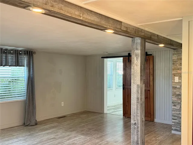 a view of a hallway with wooden floor and closet