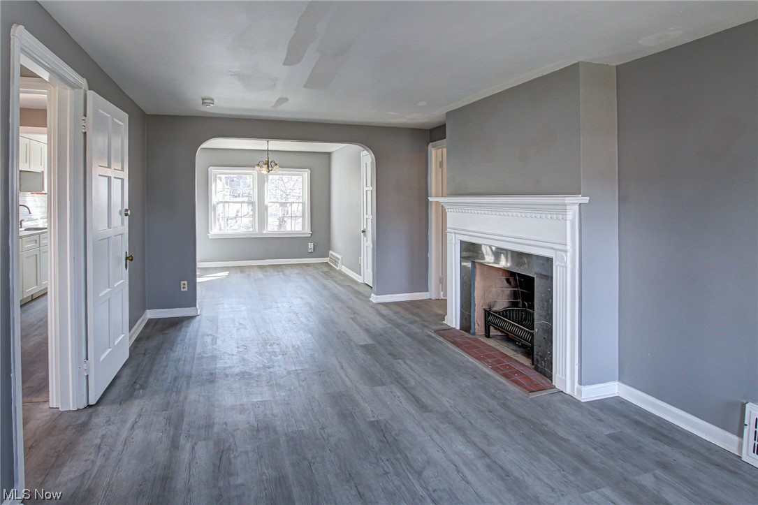 3423 Westbury Road Cleveland, OH 44120 - Photo 8 of 38 Unfurnished living room featuring an inviting chandelier, a fireplace, and dark wood-type flooring