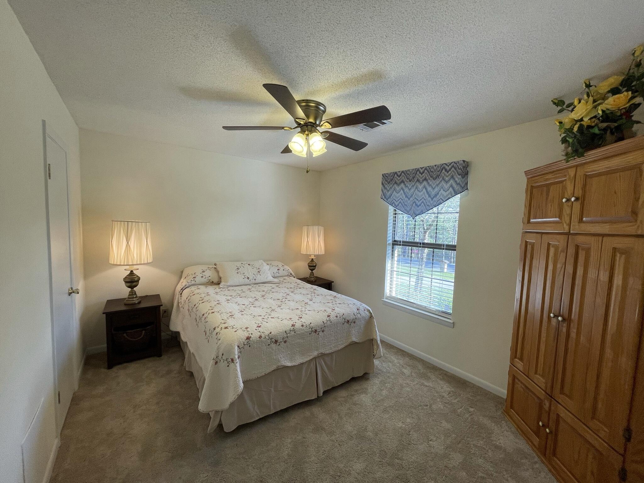 455 Ridge Lake Road Crestview, FL 32536 - Photo 15 of 22 a spacious bedroom with a bed and a chandelier