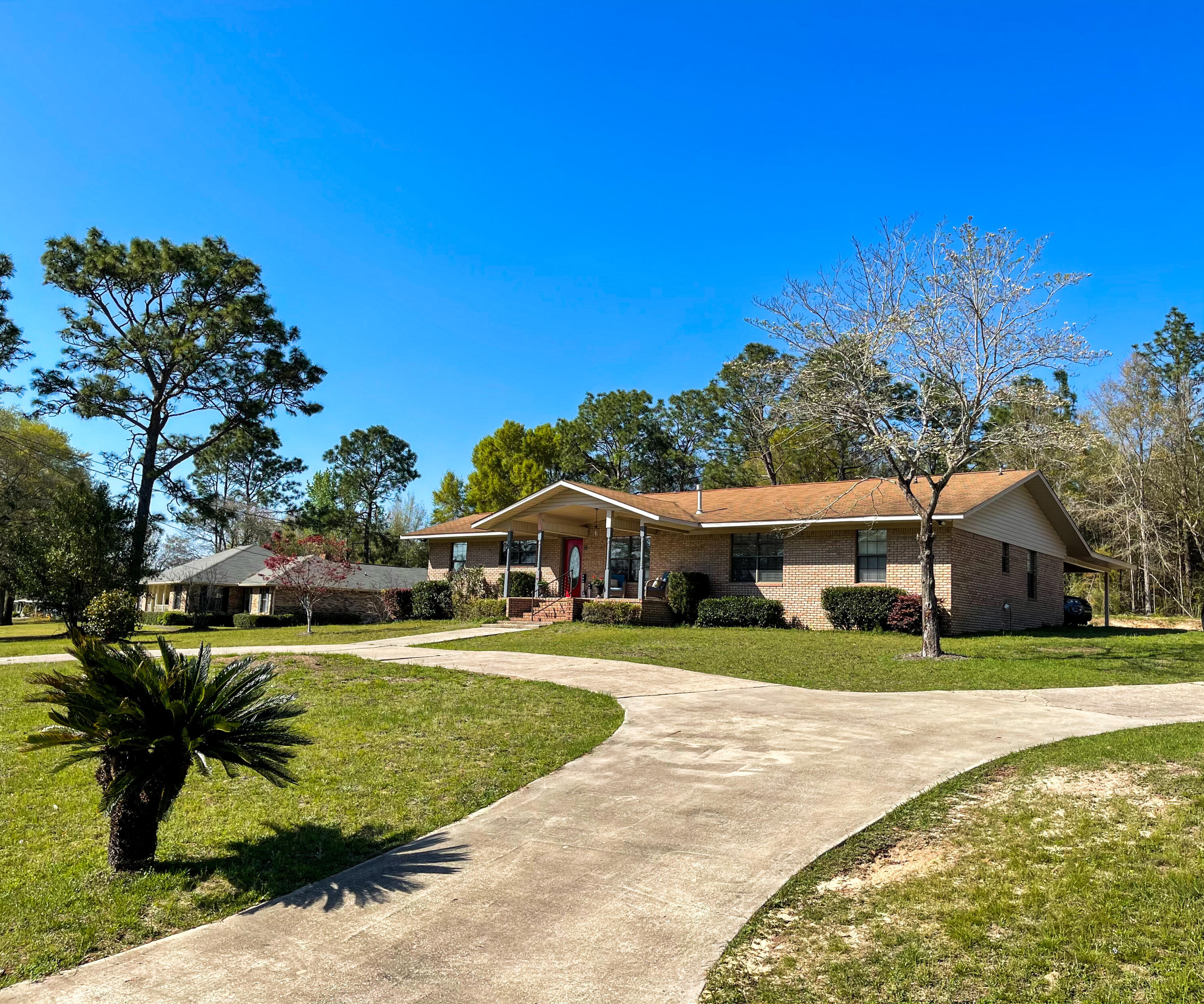 455 Ridge Lake Road Crestview, FL 32536 - Photo 4 of 22 a view of a white house with a big yard and potted plants and big trees