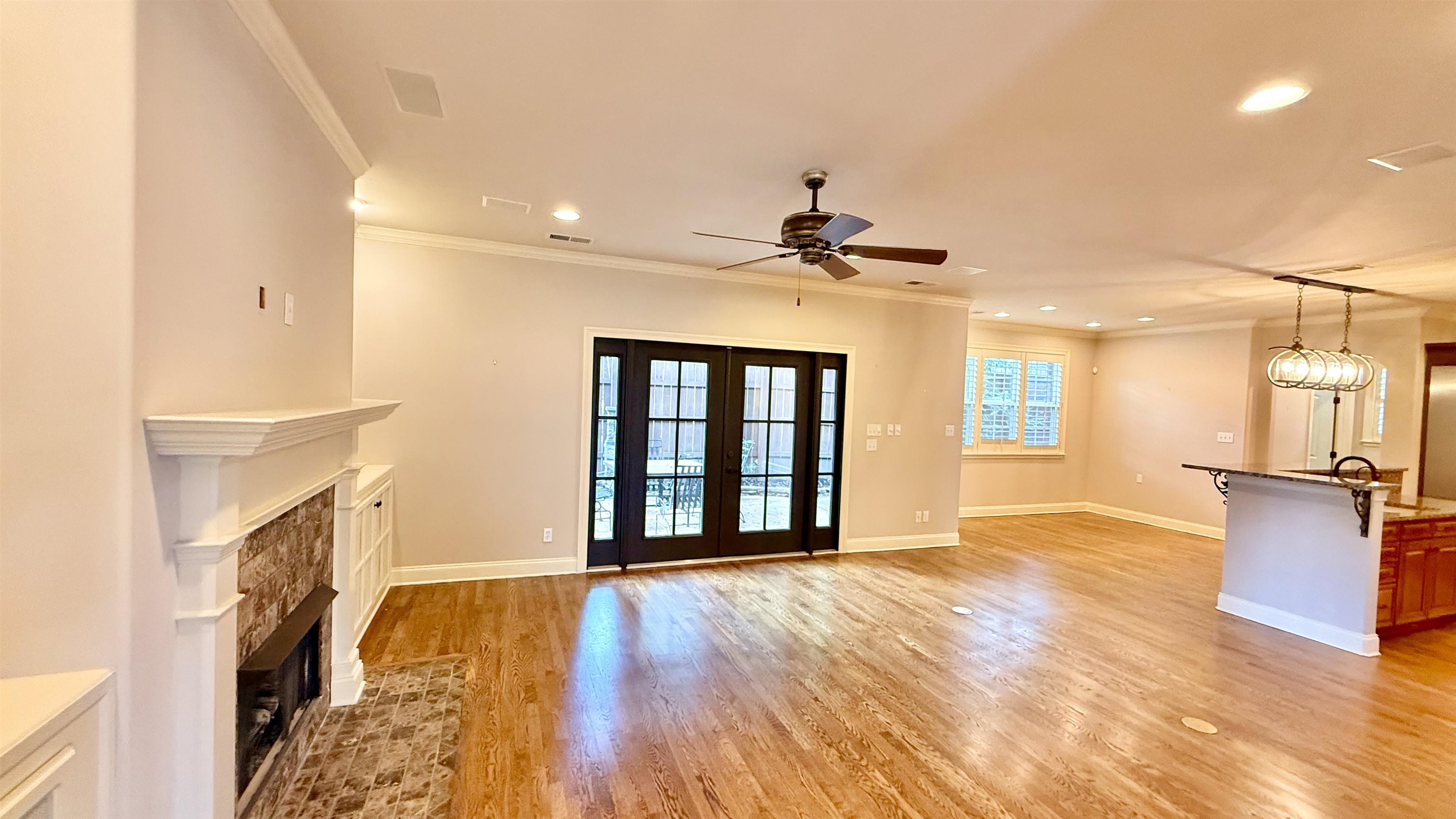 247 South Greer Street Memphis, TN 38111 - Photo 5 of 29 Unfurnished living room with a stone fireplace, crown molding, light wood-type flooring, recessed lighting, and ceiling fan
