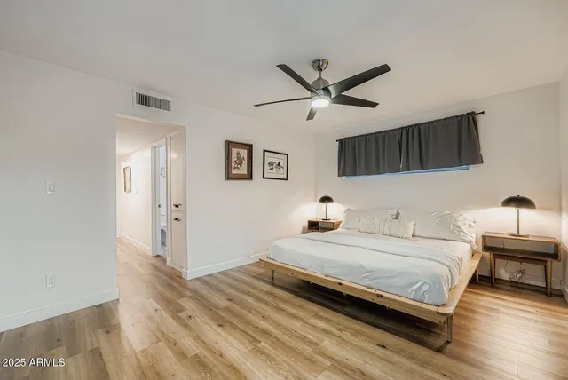 a bedroom with a bed and a ceiling fan